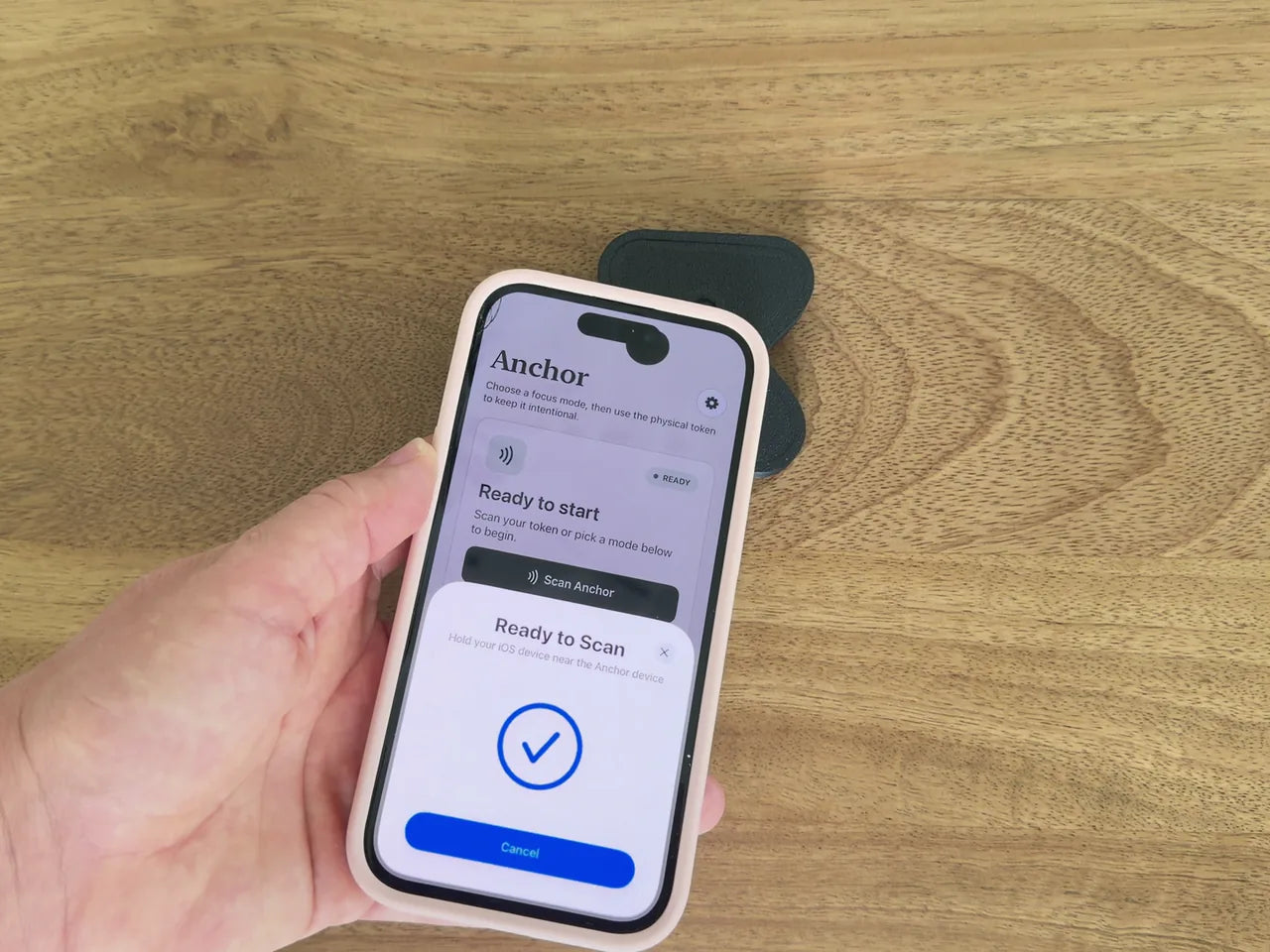 An iPhone scanning the matte-black Anchor to start a Focus session